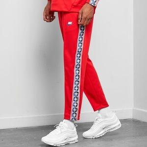 RED NIKE TAPED MONOGRAM PANTS